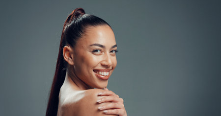 Portrait, woman or shoulder in studio with skincare for beauty aesthetic, collagen or retinol benefits. Confident, person and happiness for dermatology, wellness and mockup space on gray background.の写真素材