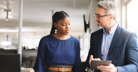 Review, guidance and businesspeople in office with tablet, discussion or evaluation of client proposal. Digital, assistance or manager in agency with tech, advice or planning for feedback report.の写真素材