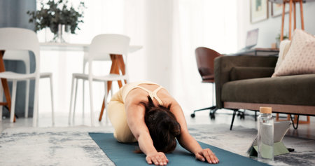 Yoga, home workout and woman stretching with tablet, warm up routine and online tutorial. Digital class, live session or person streaming fitness video in lounge, exercise mat or follow stepsの写真素材