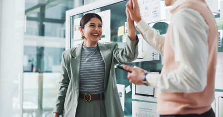 People, high five and happy for app development at startup, motivation and tablet with celebration. Woman, man and excited with goals, success and software innovation with ux design at digital agencyの写真素材