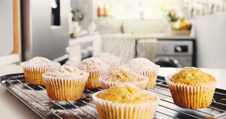 Muffin, recipe and sprinkle with powder in kitchen for sweet treat, homemade snack and preparation. Dessert, poppyseed cupcake and dust with sugar in home for topping, baked goods and breakfast food.の写真素材