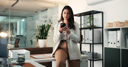 Serious, woman and texting with smartphone, office or communication with contact on break and online. Typing, message and person with mobile for digital chat, employee and networking on social mediaの写真素材