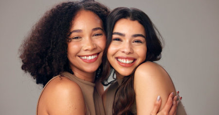 Happy women, portrait and hug with beauty, hair or fashion on a white studio background. Female people, model or smile with embrace for hair style, cosmetics or skincare treatment in salon or spaの写真素材