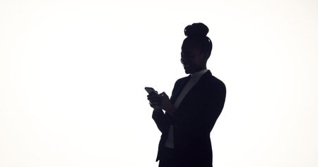 Texting, silhouette and businesswoman in studio with phone, online communication or feedback on email. Space, digital or employee on white background with tech, networking or message update on appの写真素材