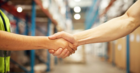 Business people, logistics or handshake with deal in warehouse for partnership, b2b or supply chain. Closeup, distributor or supplier shaking hands in aisle for shipping, distribution or wholesaleの写真素材