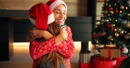 Christmas, mother and child hug in home for love, care and support with parent on holiday. Xmas, happy mom and embrace girl for connection, festive spirit and gratitude with daughter in family houseの写真素材