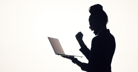 Celebration, laptop and business woman in studio for promotion, online proposal and success. Typing, mockup and person on tech with bonus, solution or planning for project on white backgroundの写真素材