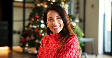 Portrait, smile and woman with Christmas in home, holiday happiness and festive season in December. Xmas time, positive spirit and excited mature person with winter sweater, vacation and decorationsの写真素材