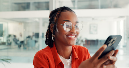 Typing, businesswoman and happy with phone in office for viral online video, post shares or chat. Social media specialist, black person or smile with smartphone for performance report or client emailの写真素材