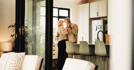 Dance, love and peace with old couple in kitchen for marriage anniversary, bonding and trust. Retirement, support and romantic music with senior man and woman in home for connection and loyaltyの写真素材