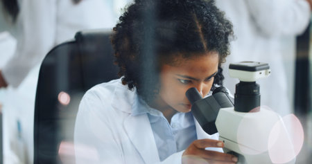 Analysis, science or woman with microscope in lab, study virus sample or experiment for pathology. Medical cure, research or scientist with trial to monitor chemical reaction, pharma test or bokehの写真素材