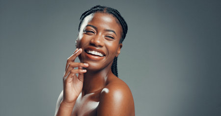 Portrait, funny and black woman in studio, beauty and dermatology on gray background. Space, shine and African person with smile, skincare and laughing with cosmetics, healthy skin and aestheticの写真素材