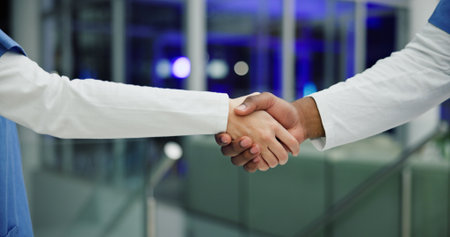 Medical, night and team in hospital with handshake, thank you and support in end of surgery. Bokeh, collaboration and nurse in clinic with hands together, well done and overtime in post operation.の写真素材