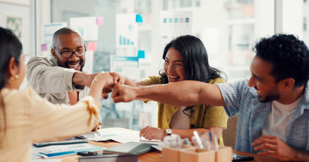 Team, fist bump and celebration with success at digital agency, motivation and goals at office meeting. Business people, smile and excited with charts, web traffic or statistics at startup companyの写真素材
