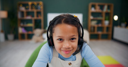 Headset, elearning and portrait of child in home for study, internet tutorial or virtual lesson. Face, remote education and girl with mic for homeschool, course or student in online class with POVの写真素材