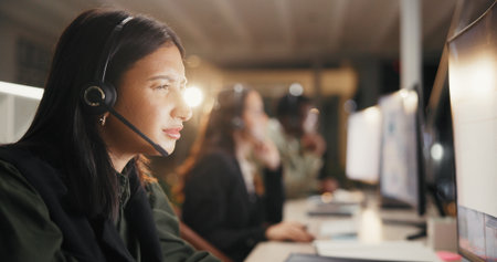 Woman, call center and confused with headset at night for customer service or consulting at office. Female person, employee or agent for error communication, reading and frustrated with overtimeの写真素材