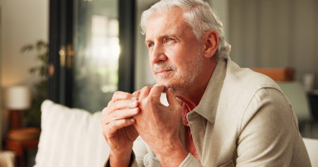 Thinking, flare and man in home with ring, issue in marriage. Mature male person in living room with wedding band, choice and reflection on separation.の写真素材