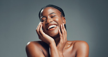 Beauty, laugh or black woman in studio for skincare, facial glow or soft texture for wellness. Dermatology, natural aesthetic or happy person with smooth skin, self care or space on gray backgroundの写真素材