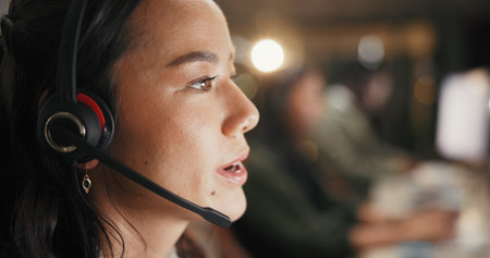 Woman, agent and night with headset for online advice or customer service in call center. Female person, consultant or working late with mic for virtual assistance, support or help in workplaceの写真素材