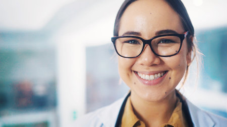 Portrait, doctor and asian woman with smile in office, physician and healthcare career in cardiology. Professional, cardiac health and specialist in hospital with space, glasses and medical servicesの写真素材