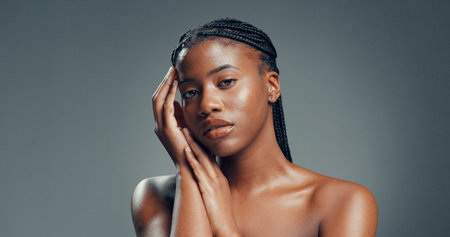 Portrait, wellness and black woman in studio, beauty and dermatology on gray background. Space, shine and African person with glow, pride and skincare with natural, healthy skin and aestheticの写真素材