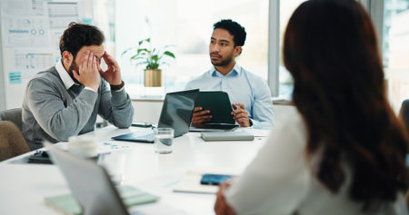 Headache, meeting and business man in office with investment loss, company bankruptcy or debt. Migraine, team or employee with stress in workplace for financial challenge, proposal mistake or burnoutの写真素材