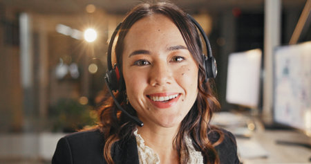 Call center, woman and happy with headset at night for tech support, network resolution or online help. Agent portrait, person and smile with mic for international inbound query, contact us and bokehの写真素材