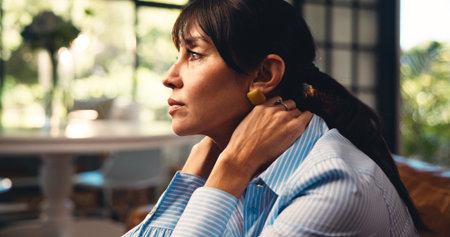 Woman, thinking and nostalgia on couch with memories, contemplation or daydreaming about past. Thoughtful, mature person or reflection on sofa for peaceful moment, relax or chill in home living room.の写真素材