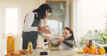 Baking, mother and kid in kitchen for meal prep, sifting flour or helping with breakfast in family home. Mixing bowl, guide and woman with girl for teaching skills, development or learning in bondingの写真素材
