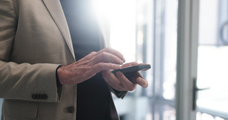Phone, hands and businessman in office with communication, networking or email for finance project. Technology, scroll and male financial manager with company cellphone for contact on investment dealの写真素材