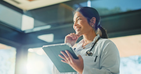 Thinking, doctor and woman with tablet for medical info, solution or telehealth in clinic. Tech, healthcare professional and person with thoughts in hospital for planning schedule, decision and smileの写真素材