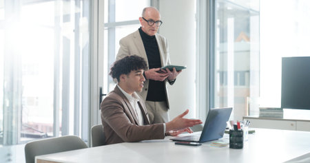 Collaboration, laptop and tablet with business people in office for development or feedback. App, review or technology with boss and corporate employee at desk in workplace for project managementの写真素材