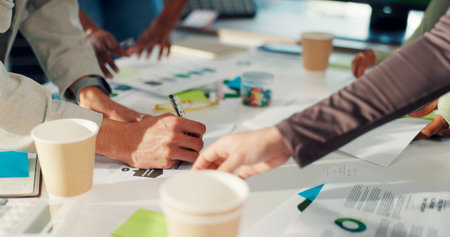 Business people, hands and meeting with documents for planning or project brainstorming in office. Group, employees or designers with paperwork or ideas for tasks, agenda or campaign in workplaceの写真素材