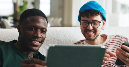 Relax, sharing and tablet with friends on sofa in living room of home together for social media. App, break and showing with roommate people in apartment for browsing, internet search or streamingの写真素材