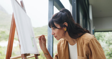 Woman, painting and brush with canvas for art, creativity or imagination for development in home. Female person, artist or painter with paintbrush or frame for skill, talent or creative inspirationの写真素材