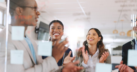 Glass wall, applause and business people in office, celebration and media agency with publication. Group, employees and journalist in workplace, cooperation and achievement with success or submissionの写真素材
