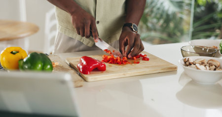 Hands, tablet or person cooking with vegetables in home for healthy lunch, online recipe or meal prep. Tech, man and cut ingredients in kitchen for dinner tutorial, website steps and culinary skillsの写真素材