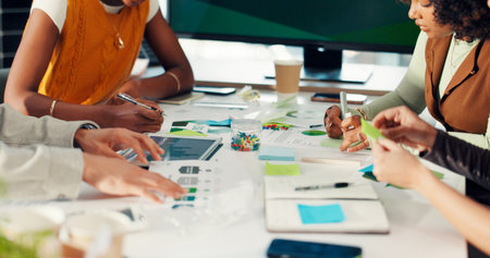 Hands, people and team at climate agency with review, sticky note and documents for sustainability. Group, staff and planning with paperwork, feedback or tablet with graphs for renewable energyの写真素材