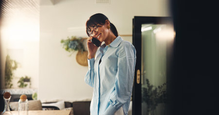 Remote work from home, phone call and woman with smile, communication and copywriting. Apartment, freelancer and mature person with cellphone, online interview and chatting with connection or contactの写真素材