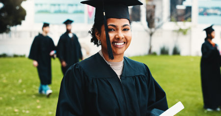 Woman, graduation and outdoor with diploma at university, celebration or portrait at campus. Person, college student and smile for success, achievement or pride with excellence certificate at academyの写真素材
