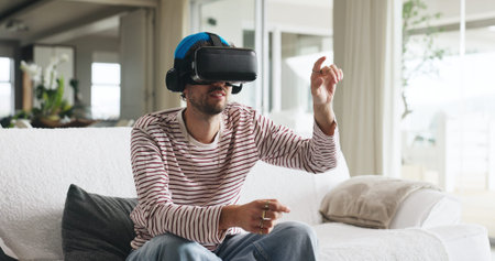 Gaming, metaverse and virtual reality with man on sofa in home for interactive experience. Online,...