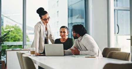 Laptop, meeting and business people in office for planning, finance report and collaboration. Tech, website and financial advisors with investment proposal, research and discussion in workplaceの写真素材