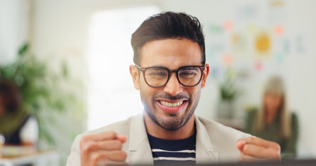 Fist pump, excited and business man in office for online bonus, financial success and investment. Startup, happy worker and person celebrate on tech with good news for promotion, winning and profitの写真素材