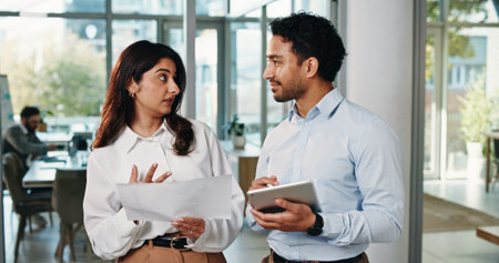 Business, people and document with tablet in office for planning, finance report and budget review. Team, talk and digital with financial paperwork, payroll procedure and feedback of investment offerの写真素材