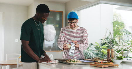 Happy, people and cooking pizza at house with meal prep, organic ingredients and healthy food. Friends, helping and grater with cheese toppings, Italian cuisine and culinary skills for homemade lunchの写真素材