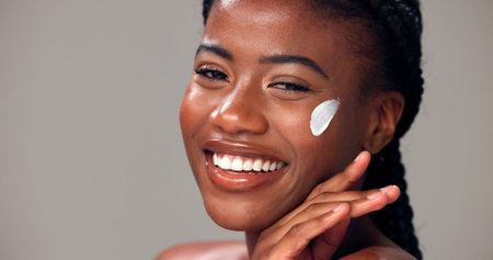 Beauty, woman and happy with face cream in studio for healthy skin, hydration and hyaluronic acid....