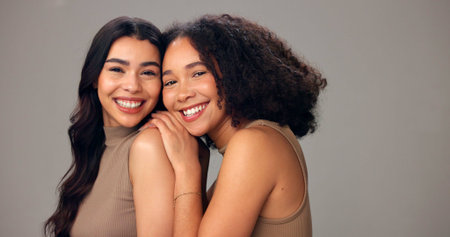 Portrait, women and laugh in studio, haircare and nourishment of texture, growth or gray background. Friends, embrace and people with smile with natural hairstyle, space or self care with cosmeticsの写真素材