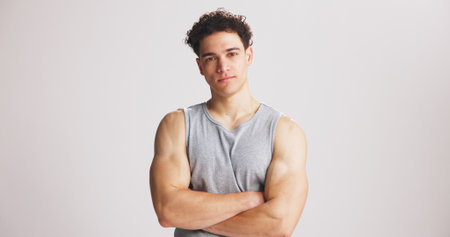 Portrait, man and bodybuilder with arms crossed in studio for fitness, exercise pride or healthy body. Mockup space, person and confidence for training, strong muscles and flexing on white backgroundの写真素材