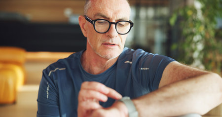 Fitness, old man and check watch in home to monitor exercise, track performance or results....