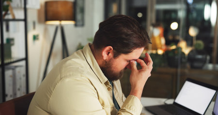 Stress, headache and businessman with laptop in office at night with finance report with deadline....